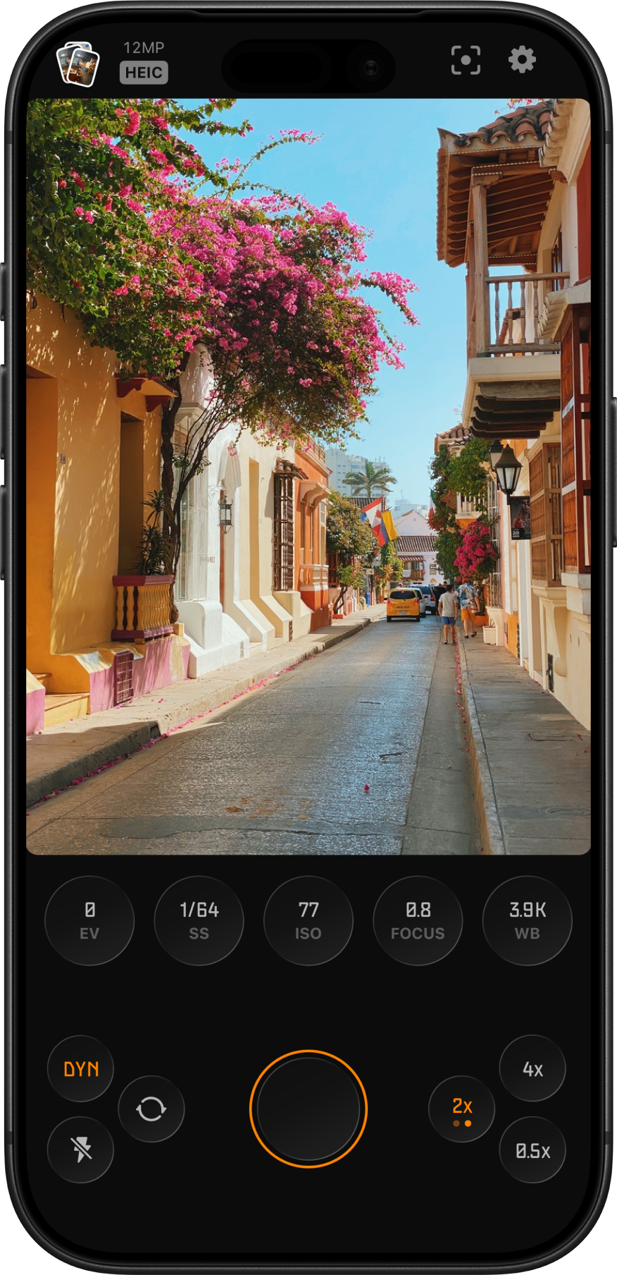Lustra running on iPhone, showing a sun-lit street viewfinder with EV, SS, ISO, focus, white balance, and zoom controls